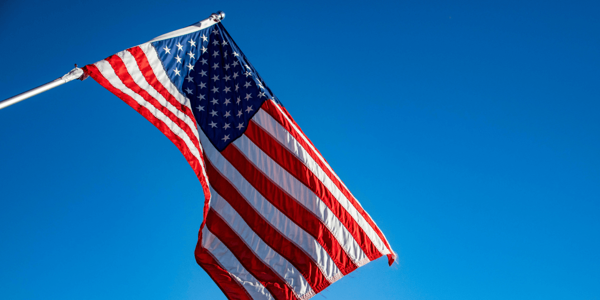 Tariffs, Premiums and Leasing Header Image American Flag on Clear Sky Background